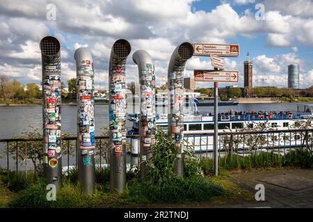 Lüftungsrohre am Rheinufer mit vielen Aufklebern bedeckt, Köln, Deutschland. Mit vielen Aufklebern beklebte Lueftungsrohre am Rheinufer, Stockfoto