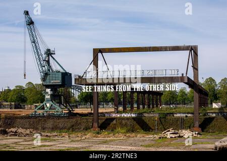 Crane und die Kunstinstallation sehen Dinge von der anderen Seite von Tim Etchells an einer alten Ladebrücke im Rheinhafen Deutz, Köln. Kr Stockfoto