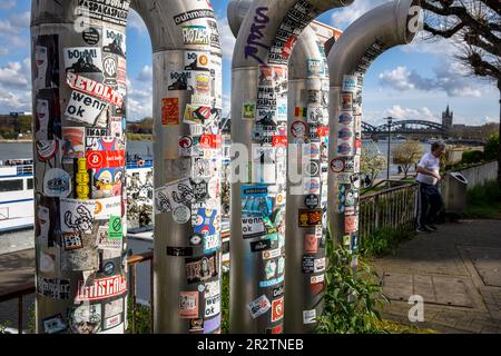 Lüftungsrohre am Rheinufer mit vielen Aufklebern bedeckt, Köln, Deutschland. Mit vielen Aufklebern beklebte Lueftungsrohre am Rheinufer, Stockfoto