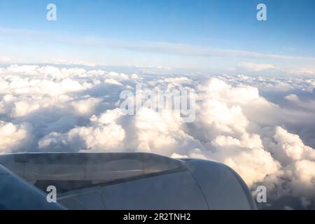 Wolken durch den Düsentriebwerk - Luftaufnahme von einem Fenstersitz im Flugzeug Stockfoto