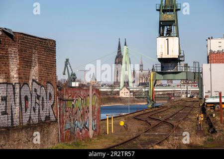 Gleise und Kran im Rheinhafen im Bezirk Deutz, im Hintergrund die Severinbrücke und der Dom Köln. Schienen und Ve Stockfoto