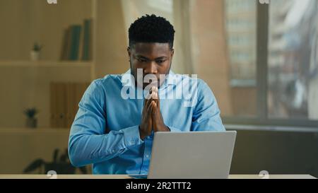 Verzweifelter, trauriger wütender afroamerikanischer Geschäftsmann Manager Unternehmer, der mit einem Laptop im Büro arbeitet, hat Computerproblem kaputtes Gerät falsch gesendet Stockfoto