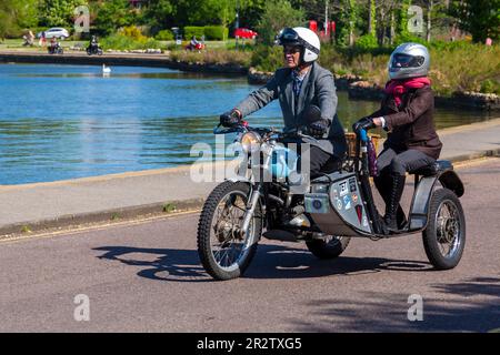 Poole, Dorset, Großbritannien. 21. Mai 2023 Bournemouth and Poole Distinguished Gentlemen’s Ride ist eine von vielen weltweit jährlich stattfindende Veranstaltung, um Geld und Bewusstsein für die Gesundheit von Männern zu schaffen. Im Rahmen der Fahrt fahren Hunderte von Motorrädern, viele davon im Vintage-Stil, durch den Poole Park auf dem Weg nach Bournemouth mit vielen ihrer Fahrer, die angemessen gekleidet sind, in Krawatten im Retro-Stil, Schnurrbart und Tweeds an einem schönen sonnigen Tag. Quelle: Carolyn Jenkins/Alamy Live News Stockfoto