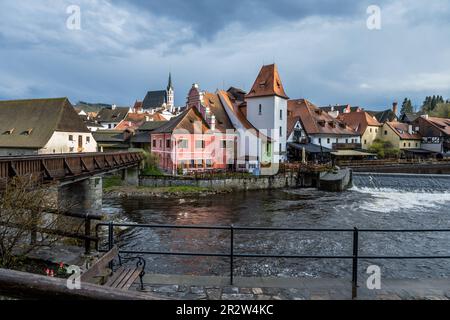 Blick auf romantische historische Gebäude mit Holzbrücke und Wehr auf der Moldau, die Altstadt von Cesky Krumlov, Tschechische republik. Stockfoto