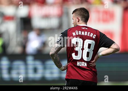 Nürnberg, Deutschland. 21. Mai 2023. Fußball: 2. Bundesliga, 1. FC Nürnberg - Hansa Rostock, 33. Spieltag im Max Morlock Stadion. Nürnbergs Jannes Horn bleibt nach der letzten Pfeife auf dem Spielfeld. Kredit: Daniel Karmann/dpa - WICHTIGER HINWEIS: Gemäß den Anforderungen der DFL Deutsche Fußball Liga und des DFB Deutscher Fußball-Bund ist es verboten, im Stadion aufgenommene Fotos und/oder das Spiel in Form von Sequenzbildern und/oder videoähnlichen Fotoserien zu verwenden oder verwenden zu lassen./dpa/Alamy Live News Stockfoto