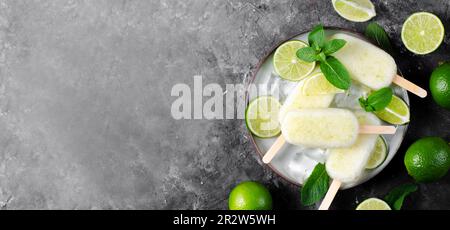 Erfrischendes Limetteneis, brasilianisches Limonadeneis Lolly mit frischer Limette und Mint auf dunklem Hintergrund, gesundes Dessert Stockfoto