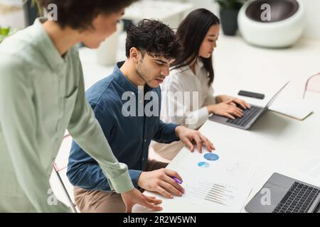 Vielfältige Geschäftsleute, Die Gemeinsam An Papers In Office Arbeiten Stockfoto