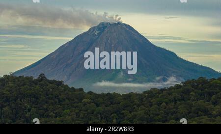 Aktiver Stratovulkan auf dem Sinabung mit Wolken bedeckt. Sumatra, Indonesien. Stockfoto