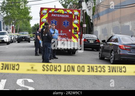 Paterson, Usa. 21. Mai 2023. Rettungsdienst und Polizisten am Tatort einer tödlichen Schießerei in Paterson. Eine Person wurde am helllichten Tag an der Kreuzung East 29. Street und 18. Avenue erschossen. Das EMS erklärte den individuellen Tod am Tatort. Die Schießerei fand gegen 8:30 UHR Eastern Time statt. Von der Polizei von Paterson waren keine weiteren Informationen sofort verfügbar. Kredit: SOPA Images Limited/Alamy Live News Stockfoto