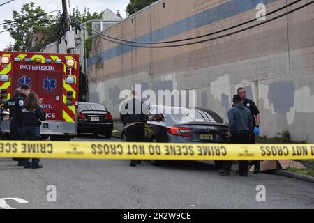 Paterson, Usa. 21. Mai 2023. Rettungsdienst und Polizisten am Tatort einer tödlichen Schießerei in Paterson. Eine Person wurde am helllichten Tag an der Kreuzung East 29. Street und 18. Avenue erschossen. Das EMS erklärte den individuellen Tod am Tatort. Die Schießerei fand gegen 8:30 UHR Eastern Time statt. Von der Polizei von Paterson waren keine weiteren Informationen sofort verfügbar. Kredit: SOPA Images Limited/Alamy Live News Stockfoto