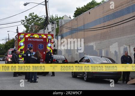 Paterson, Usa. 21. Mai 2023. Rettungsdienst und Polizisten am Tatort einer tödlichen Schießerei in Paterson. Eine Person wurde am helllichten Tag an der Kreuzung East 29. Street und 18. Avenue erschossen. Das EMS erklärte den individuellen Tod am Tatort. Die Schießerei fand gegen 8:30 UHR Eastern Time statt. Von der Polizei von Paterson waren keine weiteren Informationen sofort verfügbar. Kredit: SOPA Images Limited/Alamy Live News Stockfoto