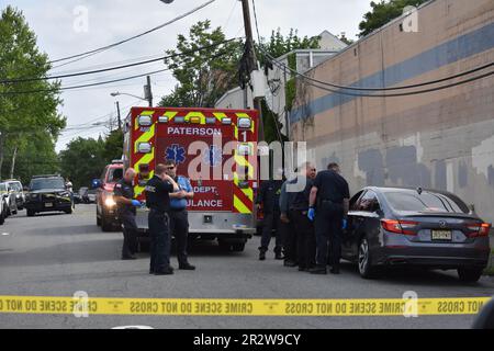 Paterson, Usa. 21. Mai 2023. Rettungsdienst und Polizisten am Tatort einer tödlichen Schießerei in Paterson. Eine Person wurde am helllichten Tag an der Kreuzung East 29. Street und 18. Avenue erschossen. Das EMS erklärte den individuellen Tod am Tatort. Die Schießerei fand gegen 8:30 UHR Eastern Time statt. Von der Polizei von Paterson waren keine weiteren Informationen sofort verfügbar. Kredit: SOPA Images Limited/Alamy Live News Stockfoto