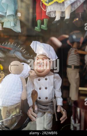 Eine Koch-Puppe hängt an einem Schaufenster Stockfoto