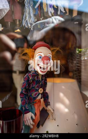 Eine Clownpuppe hängt an einem Schaufenster Stockfoto