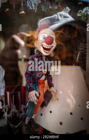 Eine Clownpuppe hängt an einem Schaufenster Stockfoto