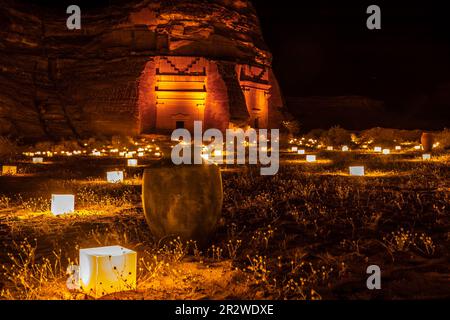 Altes Amphora vor den antiken Gräbern der Stadt Hegra, beleuchtet während der Nacht, Al Ula, Saudi-Arabien Stockfoto