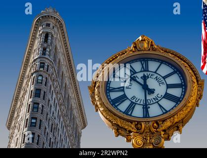 Das Flatiron Building und die nahe gelegene Fifth Avenue Building Clock sind beide Wahrzeichen von New York City. Stockfoto