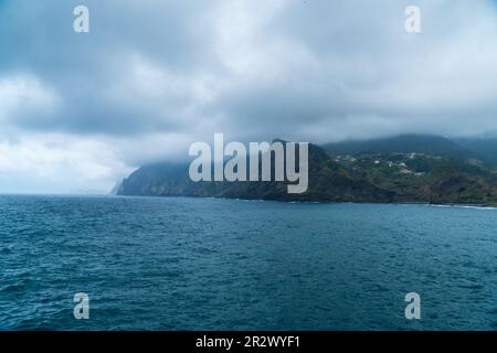 Atemberaubender Blick auf das Dorf Porto da Cruz auf Madeira, Portugal. Kleine Stadt in den Hügeln an der Küste des Atlantischen Ozeans. Dominanter Rock von Th Stockfoto