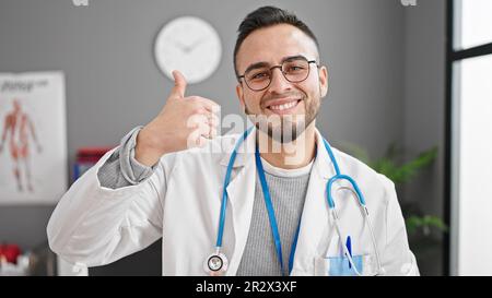 Ein hispanischer Arzt, der in der Klinik Daumen hoch hält Stockfoto