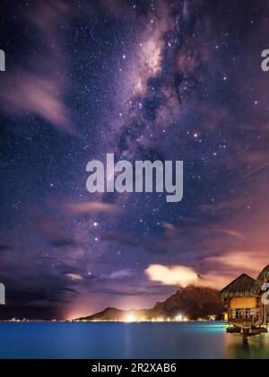 Blick auf das Milky Way Galaxy Center, das sich über dem Otemanu erhebt, von der St. Regis Bora Bora Resort's Überwasser-Luxusvilla, direkt vor Sonnenaufgang Stockfoto