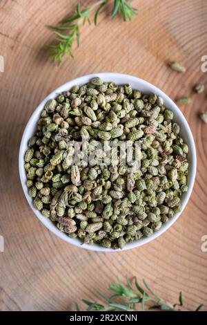 Frische grüne aromatische Thymiankräuter mit getrockneten Thymiansamen in einer Schüssel. Stockfoto