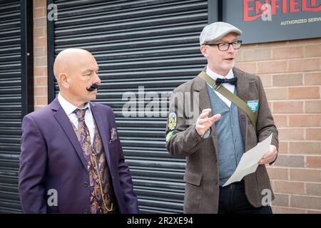 21 Mai 2023 - Warrington, Cheshire, England, Großbritannien - die Distinguished Gentleman's Ride (DGR) vereint klassische und klassische Motorradfahrer aus der ganzen Welt, um Geld und Bewusstsein für die Prostatakrebsforschung und die psychische Gesundheit von Männern zu sammeln. Eine Gruppe von Motorradfahrern aus ganz Warrington, gekleidet in ihren besten Anzügen und Krawatten, trafen sich bei ihrem Motorradhändler vor Ort und fuhren dann durch das Stadtzentrum, bevor es aus der Stadt und durch eine Kombination aus Dörfern und Städten ging. Sie erhielten vor der Fahrt Anweisungen und landeten im Besucherzentrum der Jodrell Bank. Stockfoto