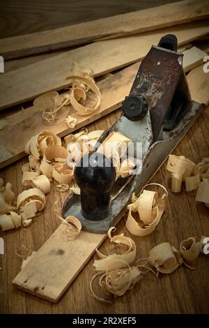 Hobel und Späne nach dem Hobeln von Holzbrettern auf Werkbank, Tischlerei, Handarbeit. Stockfoto