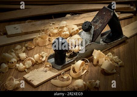 Hobel und Späne nach dem Hobeln von Holzbrettern auf Werkbank, Tischlerei, Handarbeit. Stockfoto