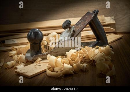 Hobel und Späne nach dem Hobeln von Holzbrettern auf Werkbank, Tischlerei, Handarbeit. Stockfoto