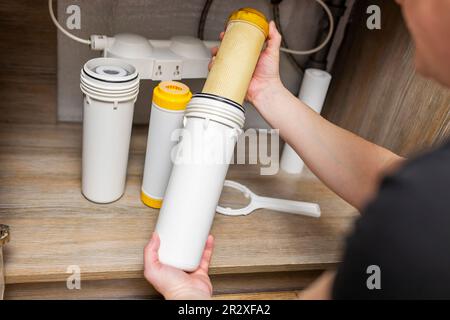 Der Installateur installiert oder wechselt den Wasserfilter. Ersatz-Aqua-Filter Stockfoto