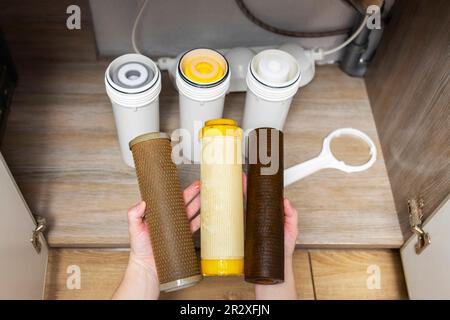 Der Installateur installiert oder wechselt den Wasserfilter. Ersatz-Aqua-Filter Stockfoto