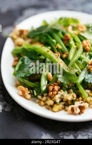 Teller mit hausgemachtem Freekeh mit grünen Bohnen und Kräutersalat. Stockfoto