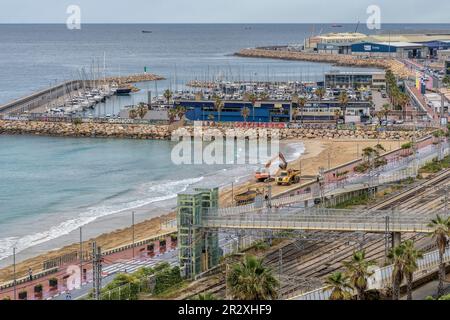 Platja del Miracle-Playa El Milagro die Promenade, die Straße und die Bahngleise mit dem Hafen der Stadt Tarragona in der Gemeinde Katalonien. Stockfoto