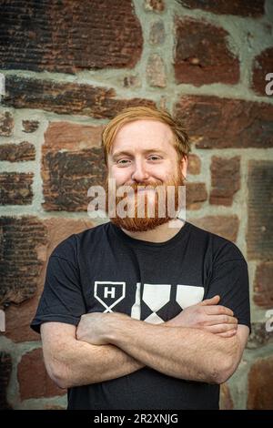 Der junge Brennereibetreiber steht zuversichtlich mit dem Ausdruck des Vertrauens in seinem Gesicht. Holyrood Destillery, Edinburgh, Schottland Stockfoto