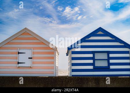 Zwei gestreifte Holzhütten mit blauem Himmel und weißen Wolken an einem Tag. Stockfoto