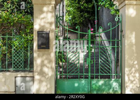 Portal eines urbanen Einfamilienhauses mit einem Metallzaun, grün und grau bemalt Granittreppe Stockfoto