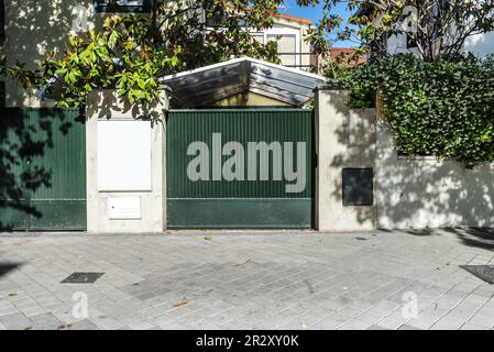 Portal eines urbanen Einfamilienhauses mit einem grün bemalten Metallzaun und einem durchsichtigen Methacrylat-Vordach Stockfoto