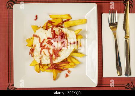 Eine einzelne Portion zerbrochenes Ei mit Schinken und Pommes frites Stockfoto