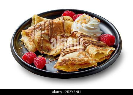 Teller mit frisch gebackenen Crepes mit Sahne und Beeren isoliert auf weißem Hintergrund Stockfoto