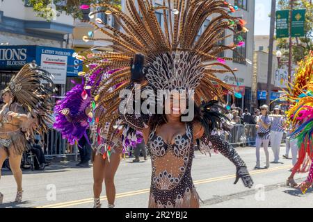 Während der Karnevalsparade, die am Sonntag, den 28. Mai 2022, durch den Mission District von San Francisco fährt, tanzen Darsteller. Stockfoto