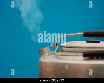 Der Dampf aus einem Wasserkocher, aus dem heißes Wasser austritt Stockfoto