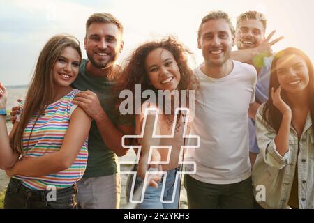 Hashtag-Symbol und eine Gruppe glücklicher Menschen machen Selfie im Freien Stockfoto