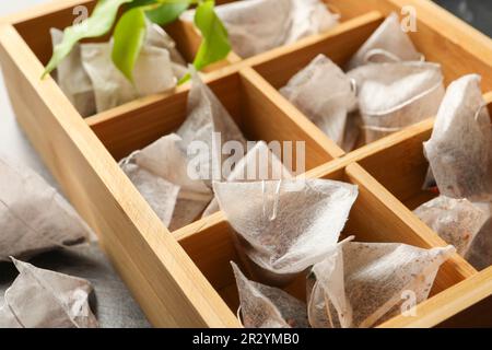 Papiertee-Beutel in Holzkiste auf dem Tisch, Nahaufnahme Stockfoto