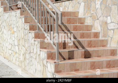 Wunderschöne geflieste Treppen mit Metallgeländern im Freien Stockfoto