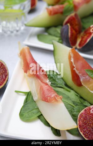 Leckere Melone, Jamon und Feigen, serviert auf weißem Teller, Nahaufnahme Stockfoto