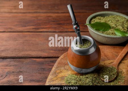 Calabash mit Mate-Tee und Bombilla auf einem Holztisch. Platz für Text Stockfoto