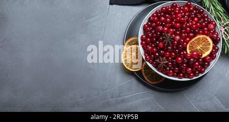 Flache Laienzusammensetzung mit frischen reifen Cranberrys auf grauem Tisch, Platz für Text. Bannerdesign Stockfoto