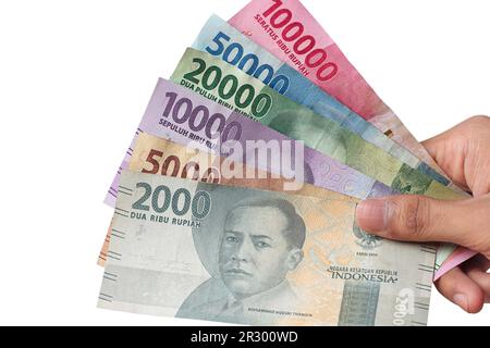 Die Hand eines Mannes, der indonesische Rupiah-Banknoten hält Stockfoto