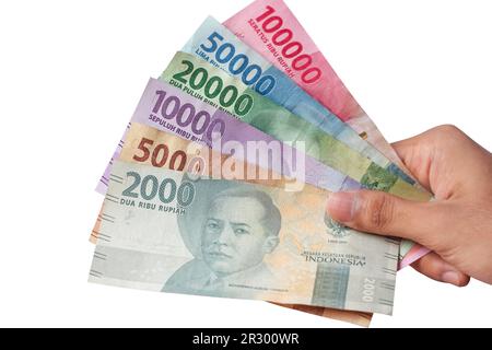 Die Hand eines Mannes, der indonesische Rupiah-Banknoten hält Stockfoto