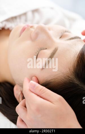 Eine Frau, die Temple Shiatsu bei Akupunktur empfängt Stockfoto